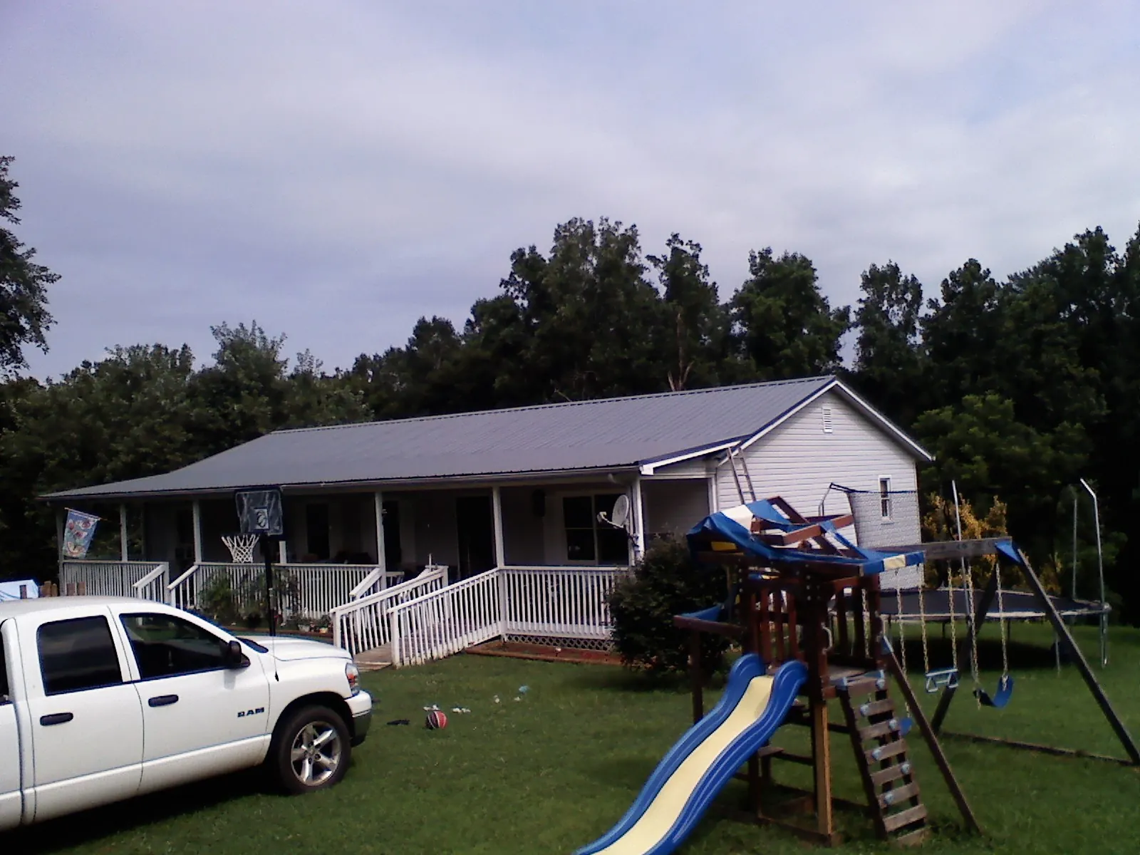 Dark metal roof on a country home with a full length front porch in Barhamsville