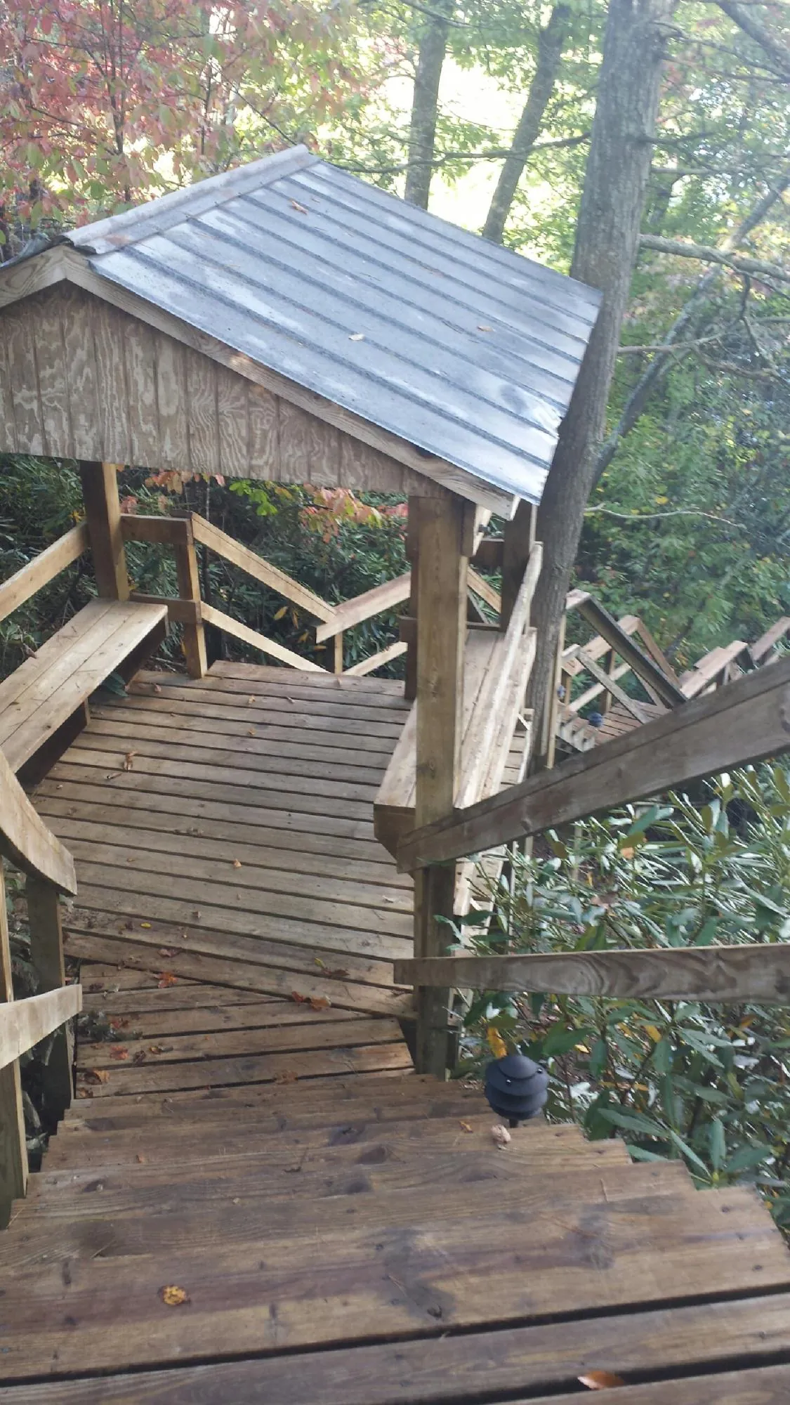 Metal roofed shelter over wooden steps on a wooded walkway — Skylight Repair & Installation work by our crew in Barhamsville