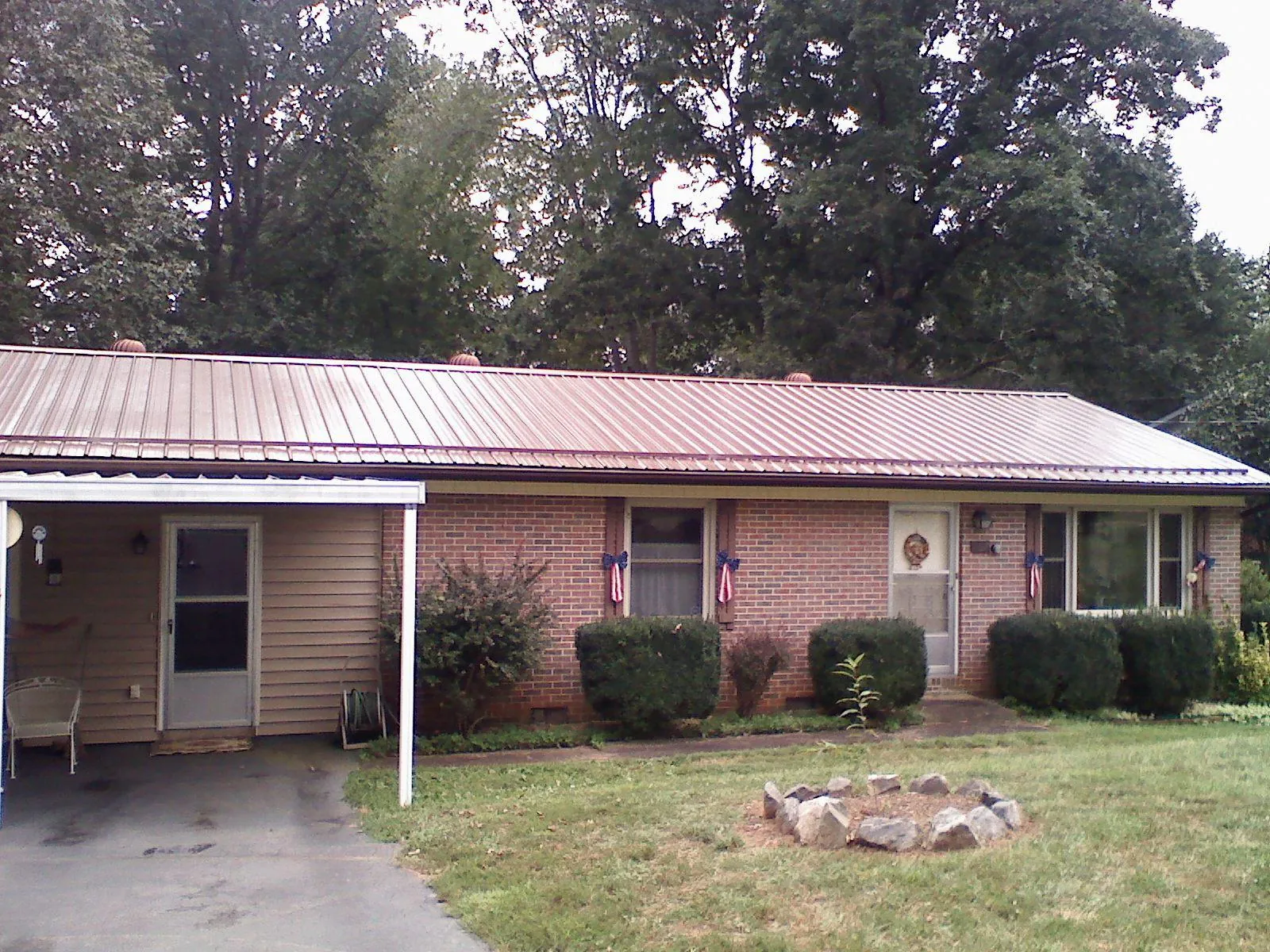 Bronze metal roof and carport on a brick ranch home — Roof Repair work by our crew in Barhamsville